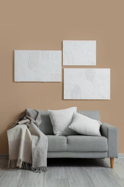 Gri kanepe ve resimlerle dolu oturma odasının içinde.