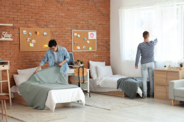 Erkek öğrenciler yurt odasını toparlıyorlar.