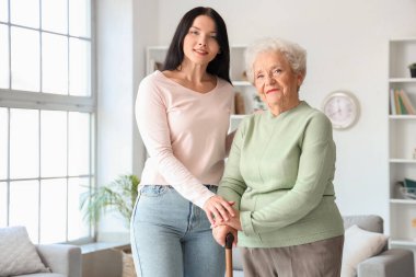 Elinde baston ve kızı olan son sınıf öğrencisi kadın.