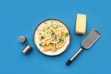 Mavi zemin üzerinde brokoli olan lezzetli bir makarna tabağı.