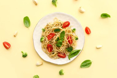 Brokolili lezzetli makarna ve sarı arka planda domates.