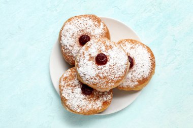 Hafif arka planda Hanuka kutlaması için lezzetli çöreklerle dolu bir tabak.