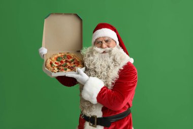 Noel Baba yeşil arka planda bir kutu lezzetli pizzayla