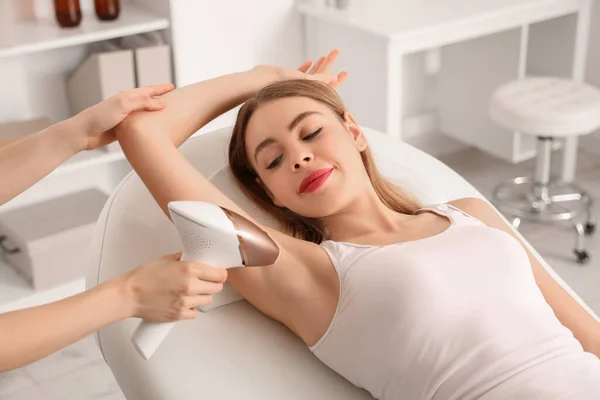 stock image Beautiful young woman undergoing procedure on her armpits of hair removing in beauty salon