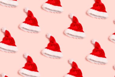 Pembe arka planda bir sürü Noel Baba şapkası. Tasarım için desen