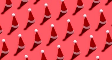 Kırmızı arka planda bir sürü Noel Baba şapkası var. Tasarım için desen