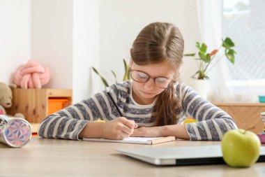 küçük kız evde ders yapıyor