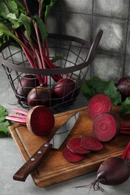 Taze pancar kökü ve gri masada bıçak ile kesme tahtası.