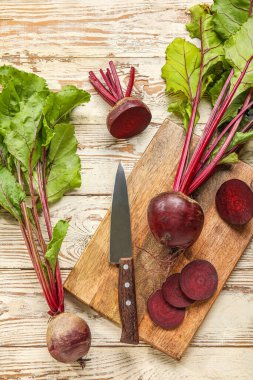 Tahta arka planda yeşil yapraklı taze pancar pancarları.