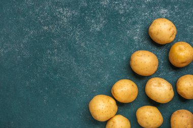 Mavi arka planda taze çiğ patates.