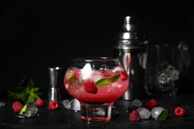 Bir bardak taze ahududu mojito ve siyah arka planda titretici.