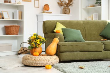 Sonbahar çiçekli balkabakları oturma odasında rattan puf üzerinde