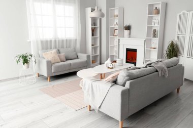 Oturma odasında rafları ve kanepeleri olan modern bir şömine.