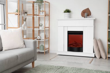 İçinde elektrikli şömine ve raf ünitesi olan oturma odası.