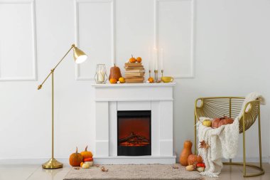 Şömineli, şatafatlı koltuklu ve balkabaklı bir sonbahar salonu.