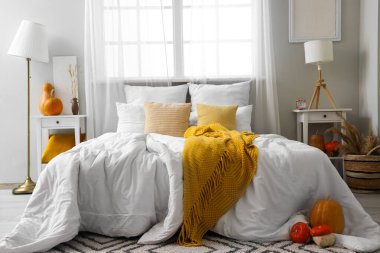 Balkabakları ve lambalarla aydınlık yatak odasının içi