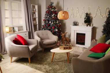 İçinde Noel ağaçları, şömine ve koltuklar olan oturma odası.