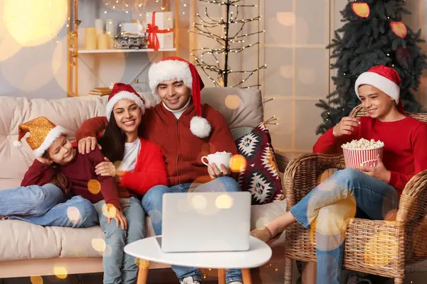 Young family watching movie at home on Christmas eve