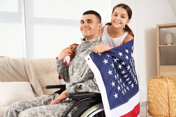 Tekerlekli sandalyedeki asker ve evinde ABD bayrağı olan küçük kızı. Gaziler Günü kutlamaları