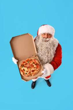 Mavi arka planda lezzetli pizzalı Noel Baba