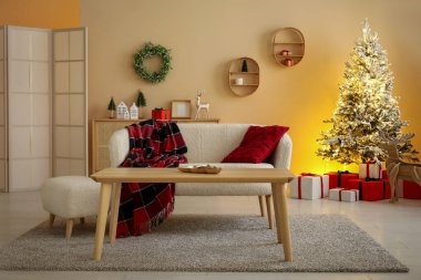 Modern oturma odasının şık iç dekorasyonu ve güzel bir Noel ağacı.