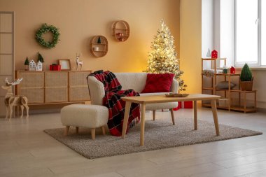 Modern oturma odasının şık iç dekorasyonu ve güzel bir Noel ağacı.