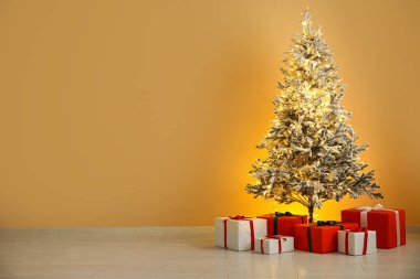 Güzel Noel ağacı ve renkli duvarların yanında hediyeler
