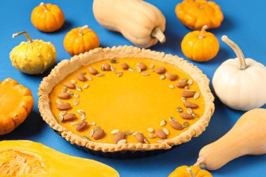 Çekirdekli balkabağı turtası ve mavi arka planda badem.