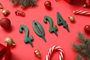 2024 model mumlarla beste ve kırmızı arka planda güzel Noel süslemeleri.