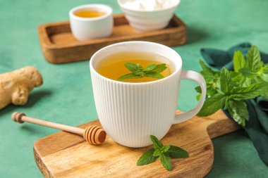 Tahta tahta tahta, taze nane çayı ve yeşil arka planda zencefil kökü.