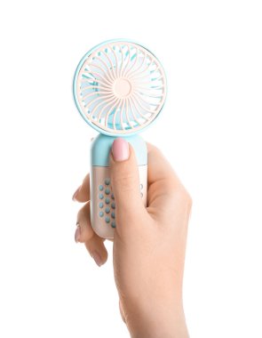 Beyaz arka planda mini elektrikli vantilatörü olan bir kadın el.