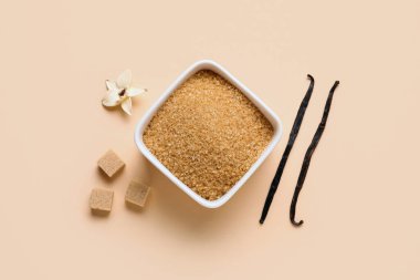 Aromatik vanilya şekeri, çiçek ve bej arka planda çubuklar olan bir kase.