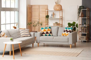 Oturma odasının içinde kanepeler ve bitkiler var.