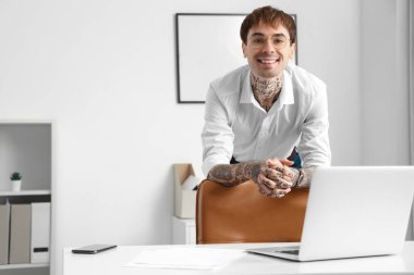 Genç dövmeli işadamı ofiste.