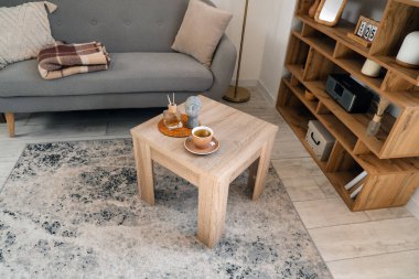 Ahşap sehpa, bir fincan sıcak çay, sazlık ayırıcı ve dekorasyon modern oturma odasında.