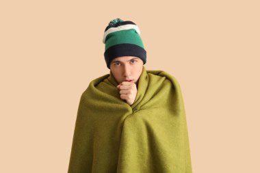 Bej arka planda ekoseli hasta genç adam.