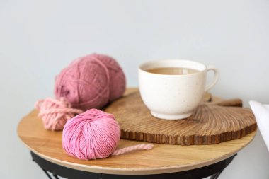 Işık duvarının yanındaki masada bir fincan çayla örülmüş iplik, yakın plan.