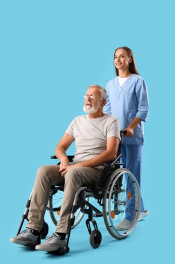 Mavi arka planda hemşire olan tekerlekli sandalyedeki kıdemli adam.
