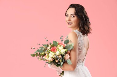 Pembe arka planda düğün buketi olan güzel gelin.