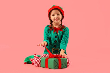 Pembe arka planda Noel hediyesi olan şirin bir elf.