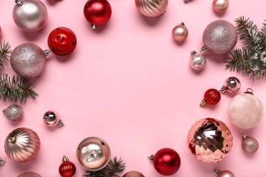 Noel toplarından yapılmış çerçeve ve pembe arka planda köknar dalları