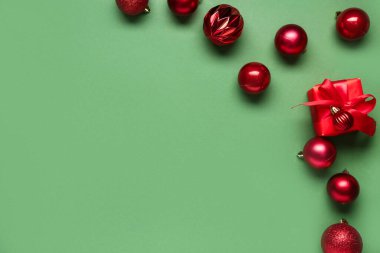 Yeşil arka planda hediyeli kırmızı Noel baloları