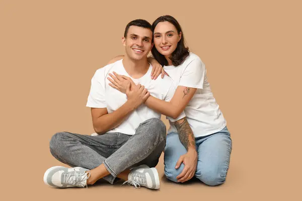 Happy Young Couple Sitting Floor Hugging Beige Background — Stock Photo, Image