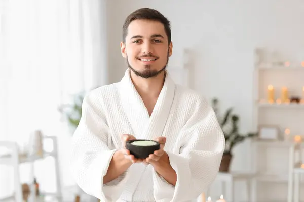 Young man with sea salt in spa salon