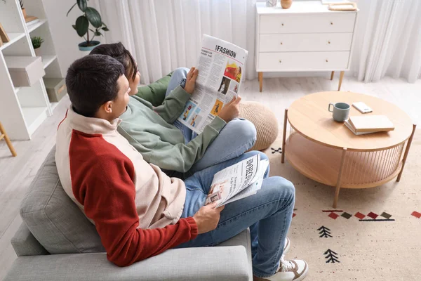 stock image Young couple with newspapers at home