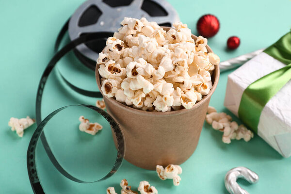 Ведро попкорна с пленкой и подарочной коробкой на бирюзовом фоне