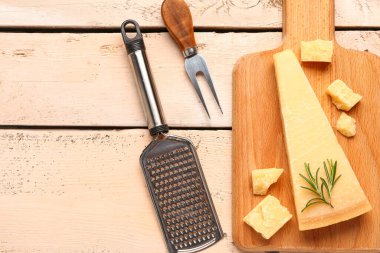 Hafif ahşap arka planda lezzetli parmesan peyniri parçaları olan tahta.
