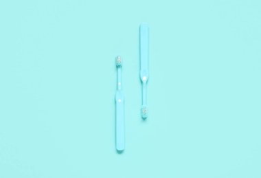 Renkli arkaplanda iki mavi diş fırçası.