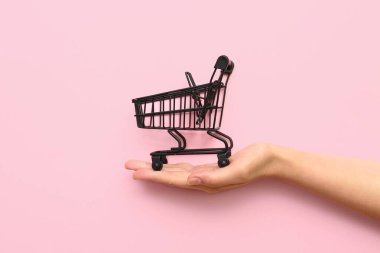 Arka planda siyah alışveriş arabası olan bir kadın..