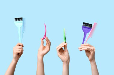 Renkli arka planda saç malzemesi olan kadın eller..